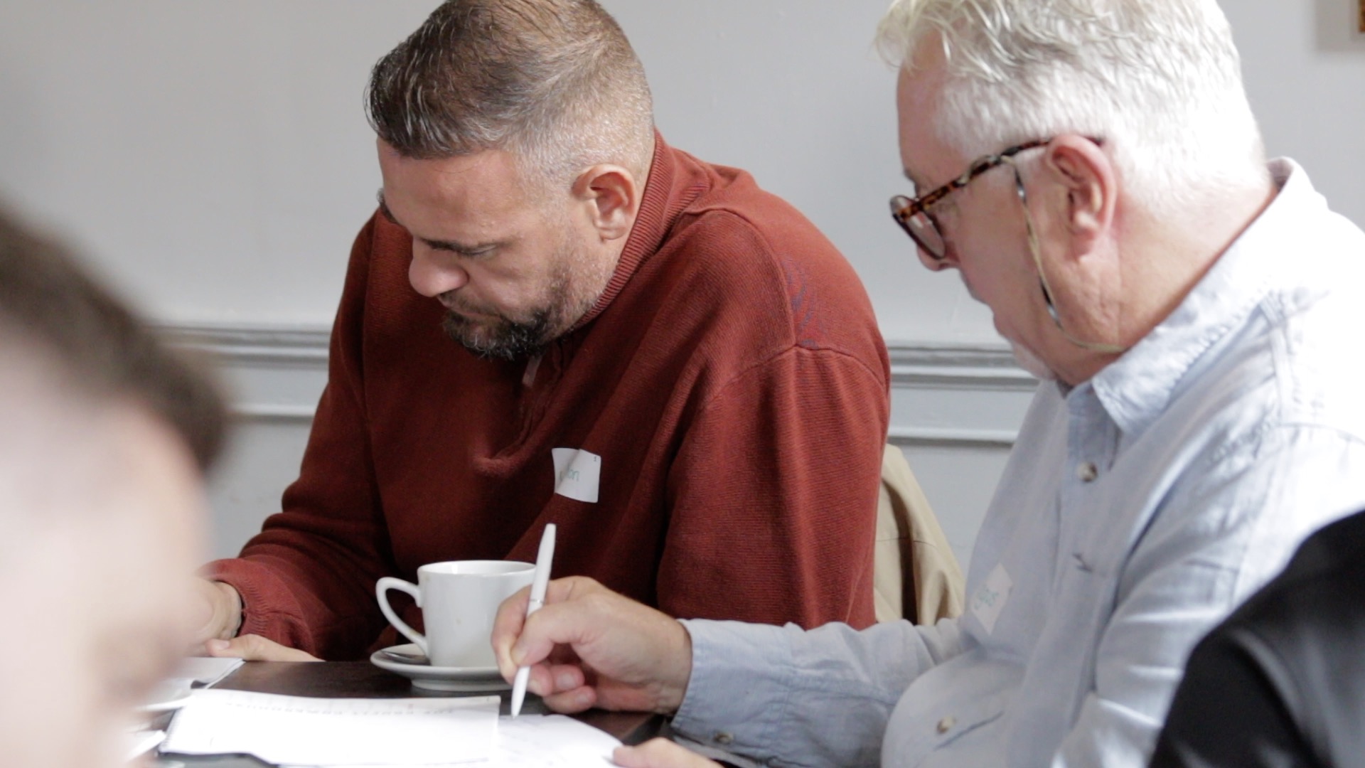 Two recruitment leaders writing during a Coach Recruitment workshop